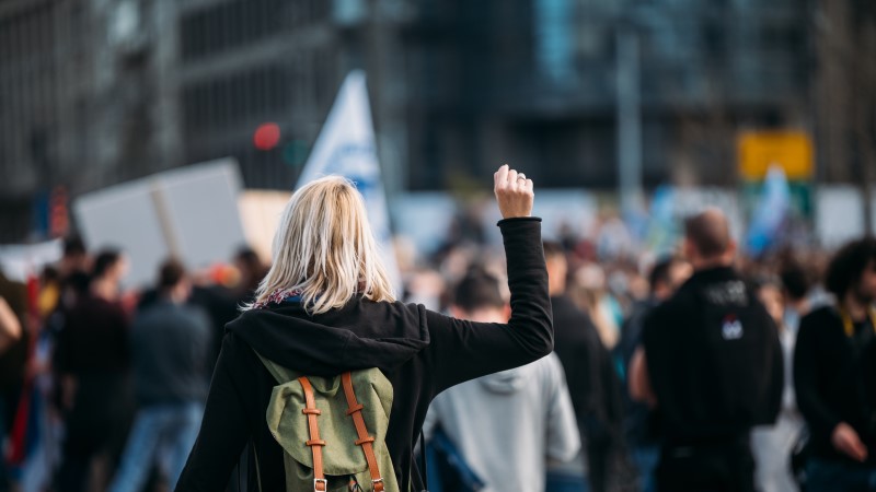 Woman at a protest march raising fist